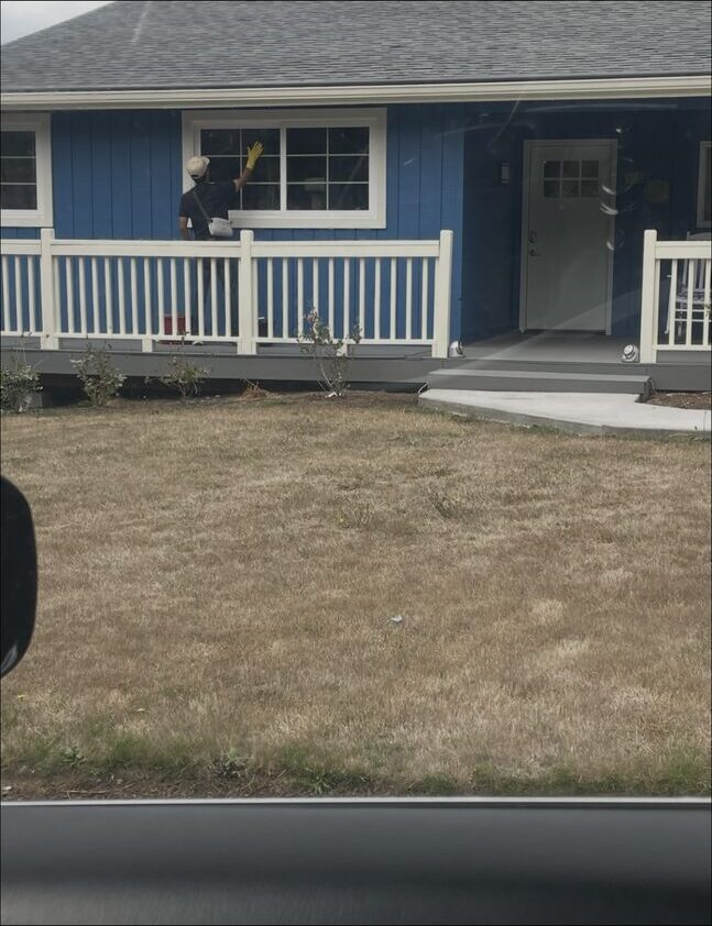 Carlos Montes cleaning a window on his first-ever customer's house